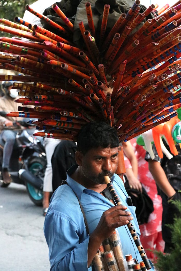 Home Musician selling bamboo flutes on a busy street in Lalitpur, capturing authentic Nepali culture.