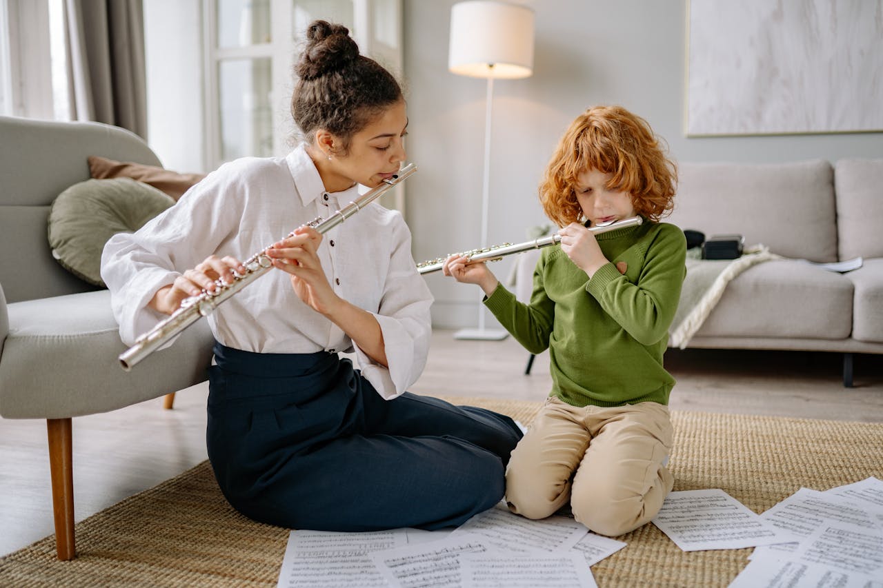 Home Woman teaching young boy to play flute in a cozy living room setting.